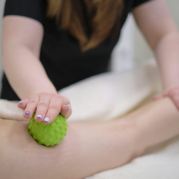Woman at the physiotherapy receiving ball massage from therapist. Woman at the physiotherapy receiving ball massage from therapist.
